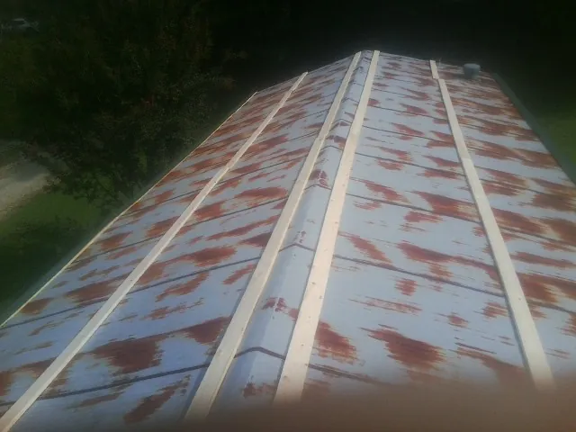 Rusted metal roof panels with new wood purlins before replacement — Storm Damage Roof Repair in Ellsworth by Roofing Brothers