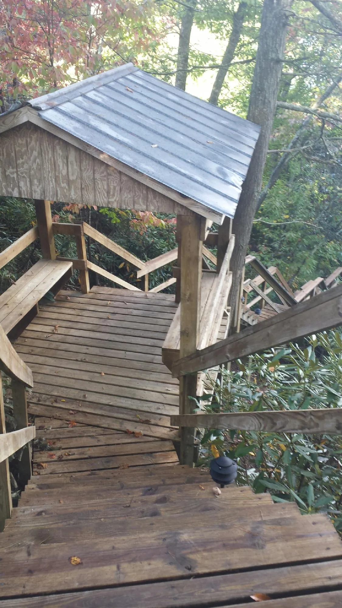 Metal roofed shelter over wooden steps on a wooded walkway — Skylight Repair & Installation work by our crew in Ellsworth